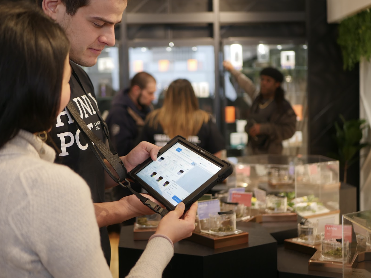 Sales associate using a tablet at point of sale for a customer in a tech enabled coffee shop