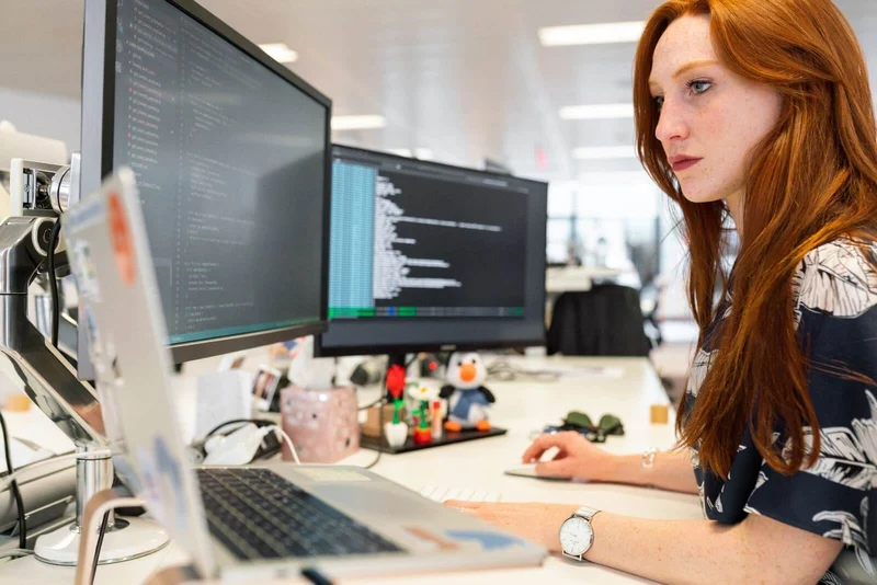 female developer working at two monitors 