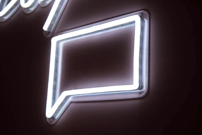 A neon sign showing a chat icon.
