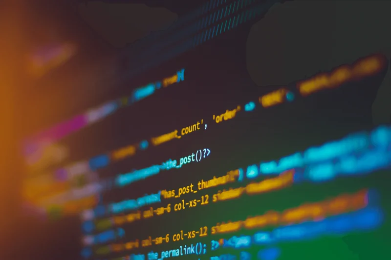 A macro photograph of a computer screen showing programming code.