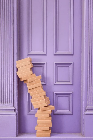 IT assets illustrated as boxes stacked on top of each other, in front of a bright, purple doorway