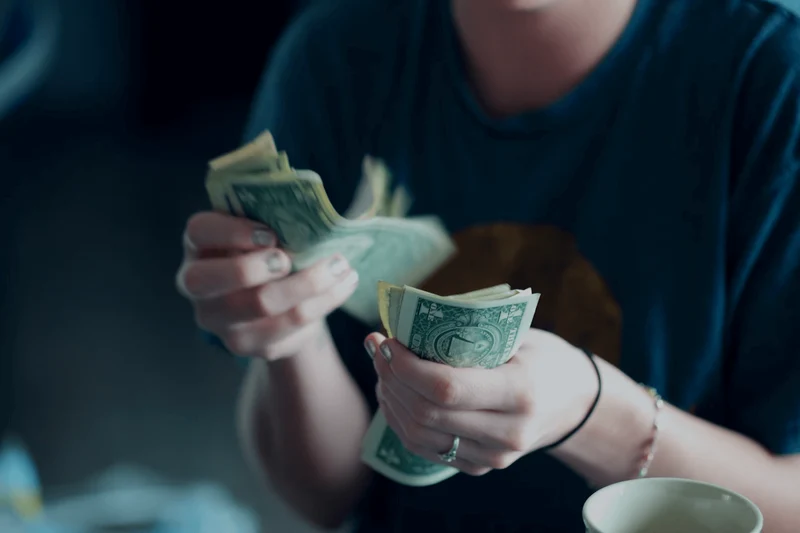 A photograph of a person counting money.