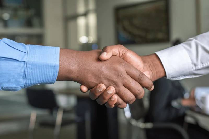 Two hands meet in a business handshake. 