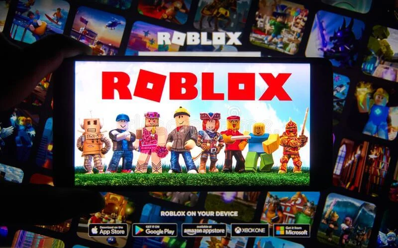 A phone screen showing the Roblox home page with different gaming characters in the background.