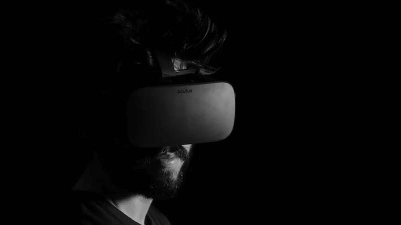 Close up of a man wearing a black Oculus VR headset