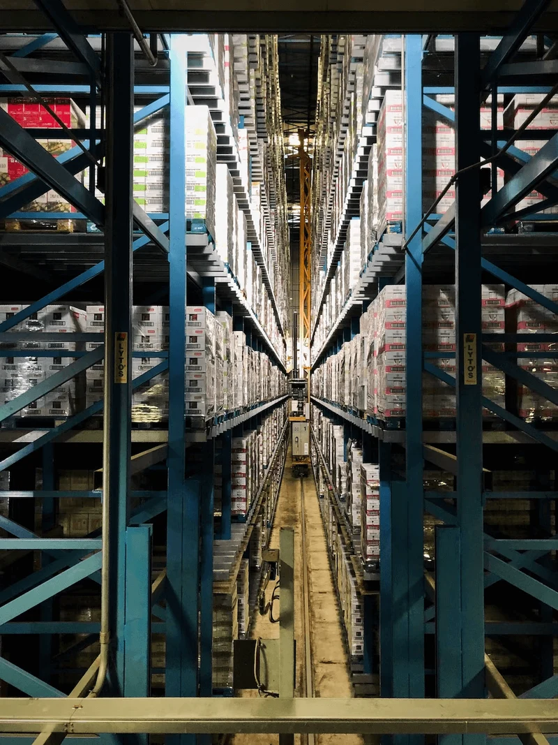 A photograph of inside a warehouse with cross beams in the foreground. 